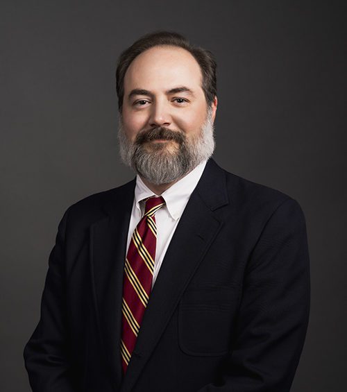 John Philip Fox, attorney at Adams, Hemingway, Wilson & Rutledge, LLC, wearing a white dress shirt and red tie under a black suit jacket.